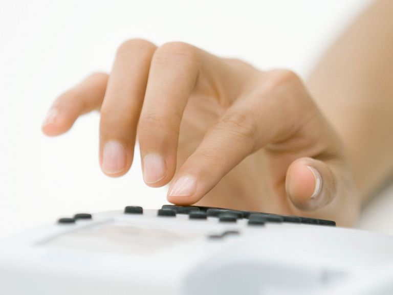 Frauenhand beim Wählen einer Telefonnummer