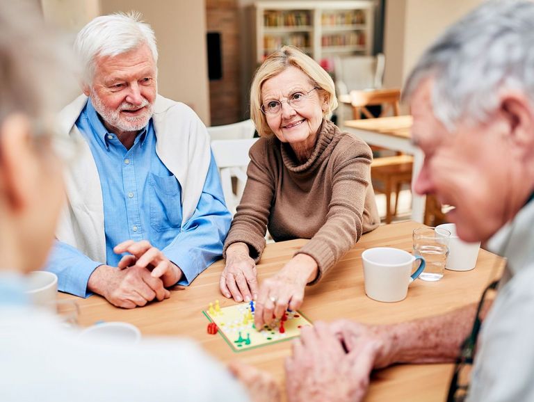 Wohngruppe mit Rentnerin beim gemeinsamen Spielen