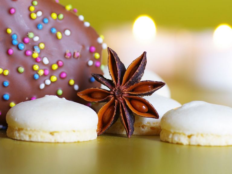 Anisplätzchen und Sternanis vor weihnachtlichem Hintergrund