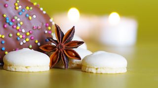 Anisplätzchen und Sternanis vor weihnachtlichem Hintergrund