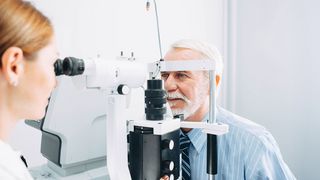 BesserGutSehen Augenärztin untersucht mit einem Spezialgerät die Augen eines älteren Mannes