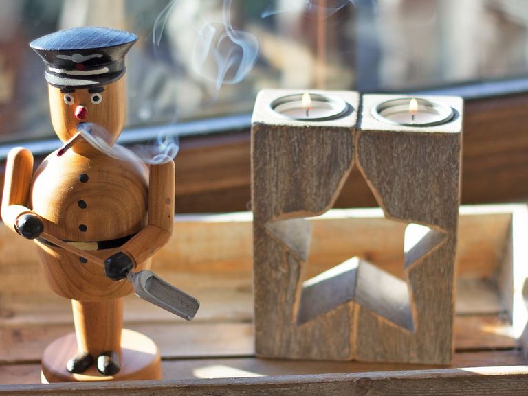 Rauchermännchen und Adventskerzen auf einem Fensterbrett