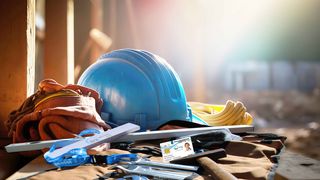 Handwerksberufe Blauer Helm und Arbeitskleidung auf einer Baustelle in der Abenddämmmerung