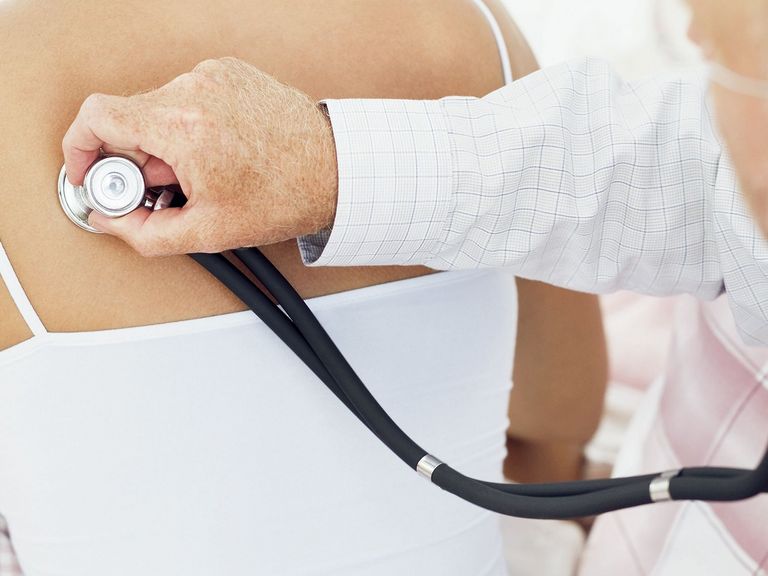 Arzt hört Lunge von Patientin mit Stethoskop ab