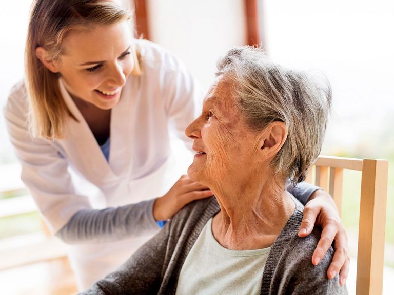 Pflegerin betreut fröhlich eine Pflegebedürftige