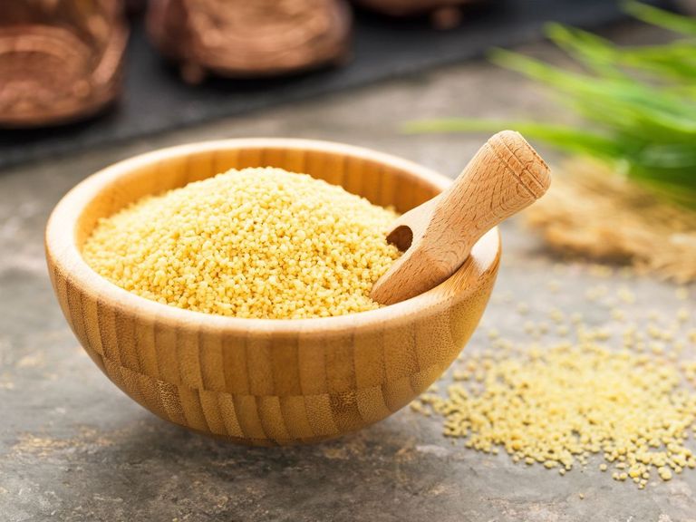 Bambusschale mit trockenem Bulgur und einem kleinen Holzschäufelchen