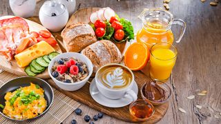 Gesunde Ernährung Rustikaler Holztisch gedeckt mit einem reichhaltigem und abwechslungsreichen Frühstück