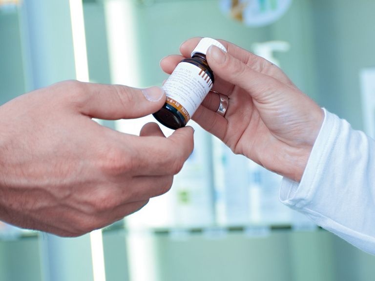 Apothekerin reicht Arzt Medikament