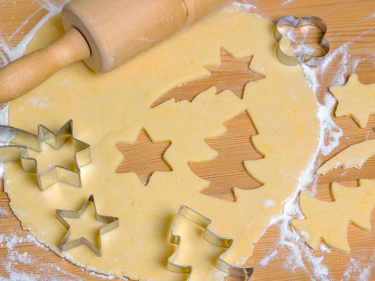 Weihnachtliche Ausstechförmchen und ausgerollter Plätzchenteig