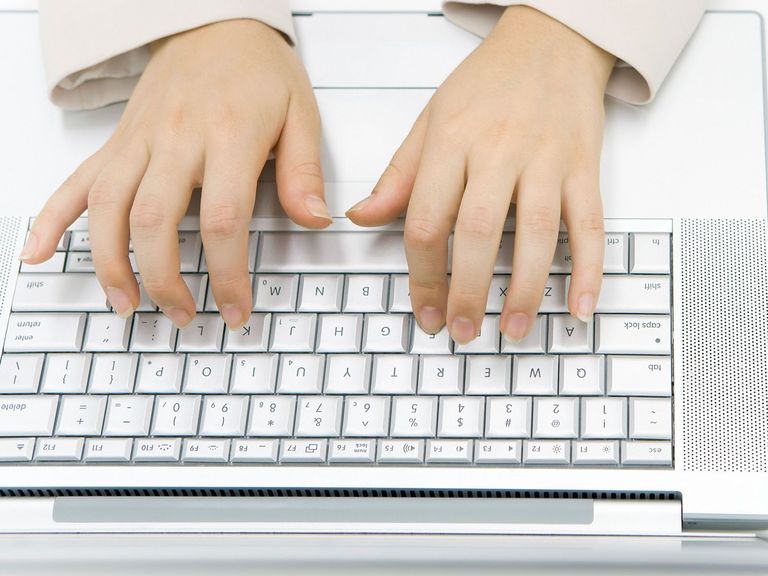 Frau schreibt auf einer Laptoptastatur