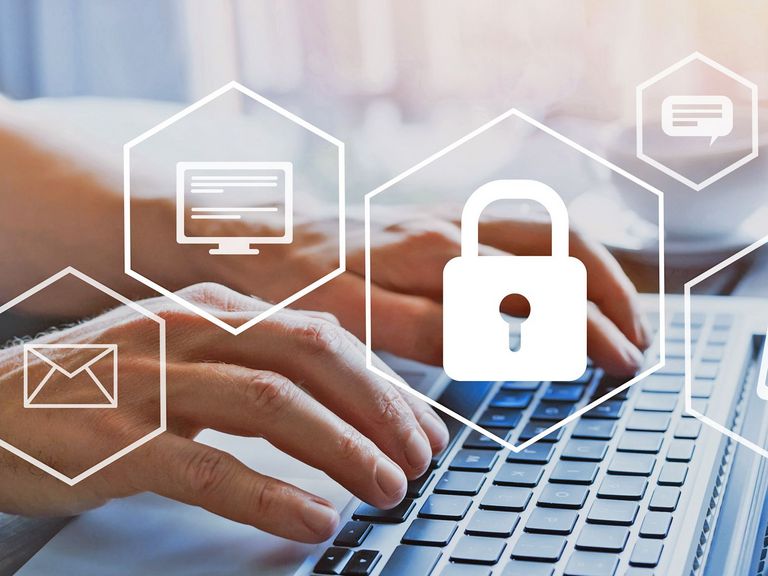 Hände tippen auf einer Laptop-Tastatur mit einem Schlosssymbol im Bildvordergrund
