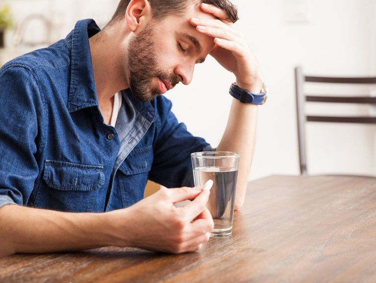 Mann nimmt eine Tablette gegen Sodbrennen