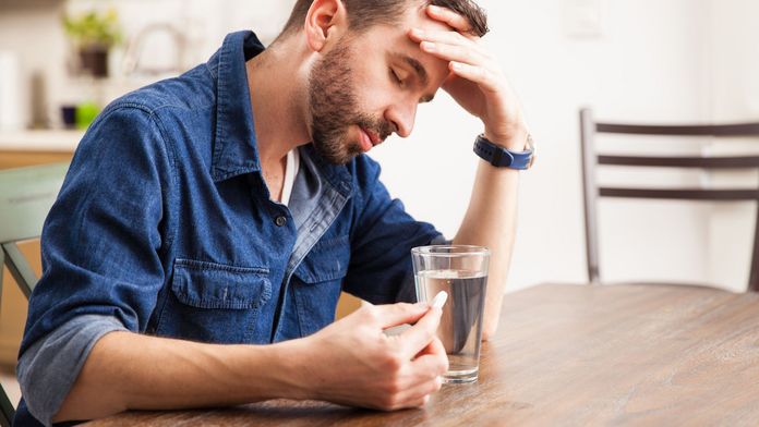 Mann nimmt eine Tablette gegen Sodbrennen