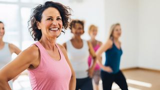 Frauengesundheit Frau im mittleren Alter nimmt mit einem Lächeln an einer Sportgruppe teil