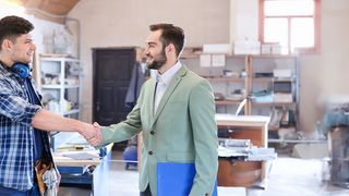 Zukunftsmacher im Handwerk Handschlag vom Arbeitgeber mit seinem Azubi in einer Werkstatt