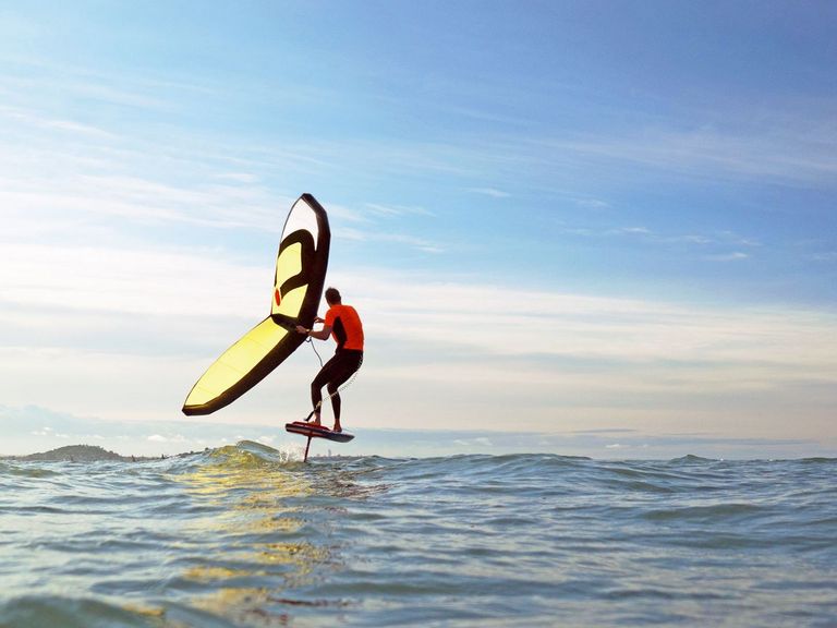 Mann beim Wing Foiling auf dem Meer