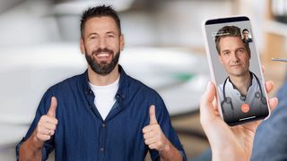 TeleClinic Hände halten ein Fieberthermometer und ein Smartphone