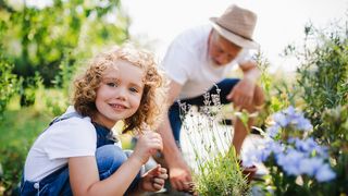 Gartenarbeit Mädchen und ihr Großvater arbeiten gemeinsam im Garten
