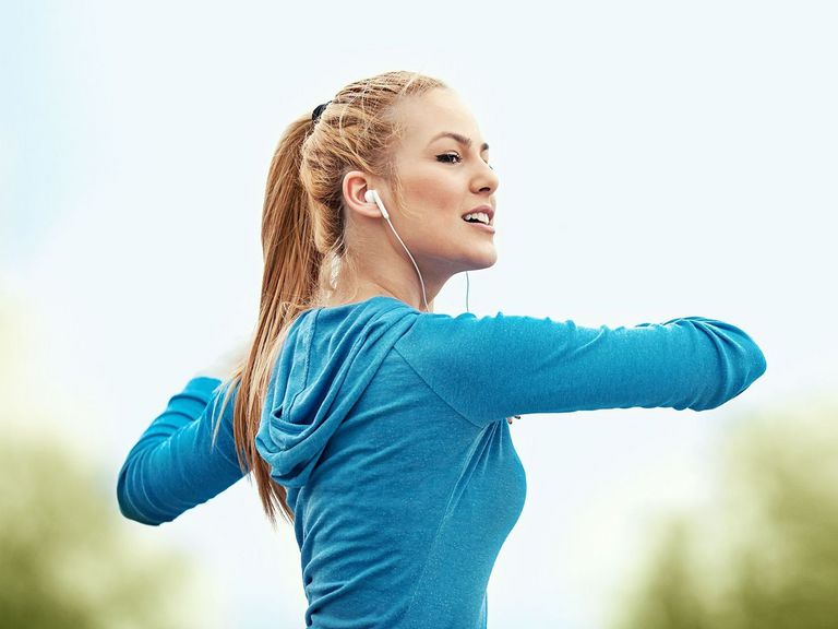 Blonde Frau mit einer türkisfarbenen Jacke bei ihrem Feierabend-Workout