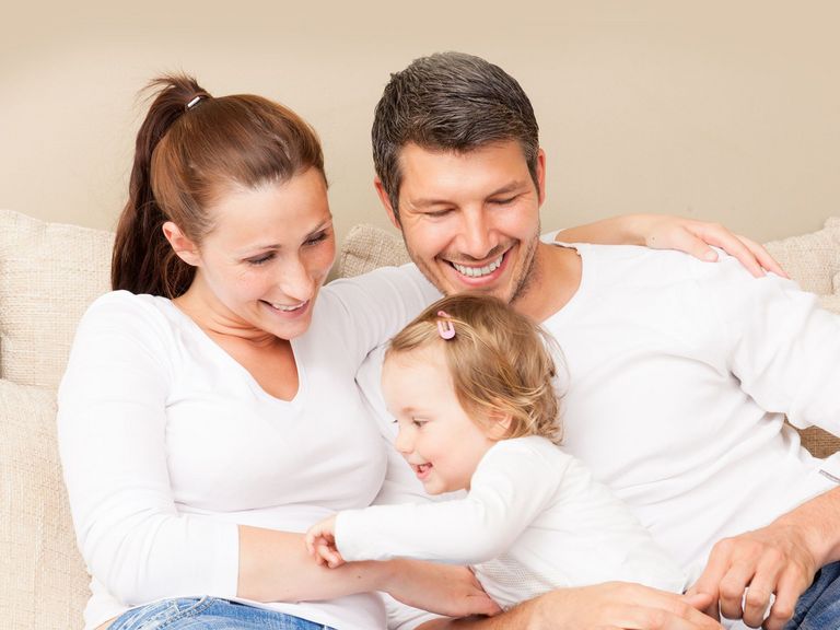 Eltern mit Kind sitzen auf einem Sofa