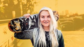 Junge blonde Frau mit Skateboard über der Schulter