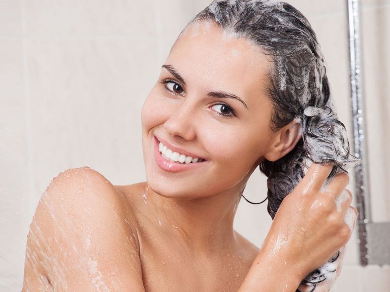 Frau wäscht sich unter der Dusche die Haare