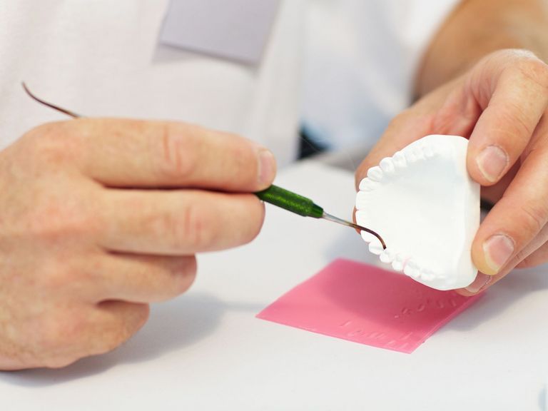 Zahntechniker bearbeitet Zahnersatz 