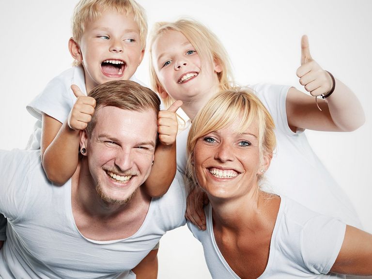 Vierköpfige Familie lacht in die Kamera