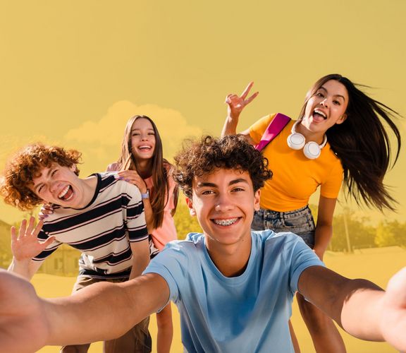 Vier Jugendliche lachen in die Selfiekamera