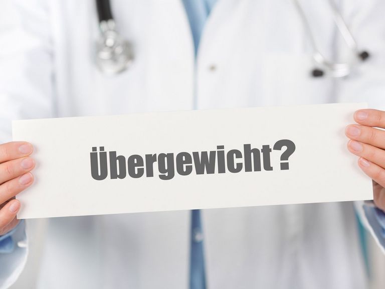 Arzt hält ein Schild mit der Aufschrift "Übergewicht"