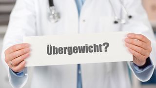 Übergewicht Arzt hält ein Schild mit der Aufschrift "Übergewicht"