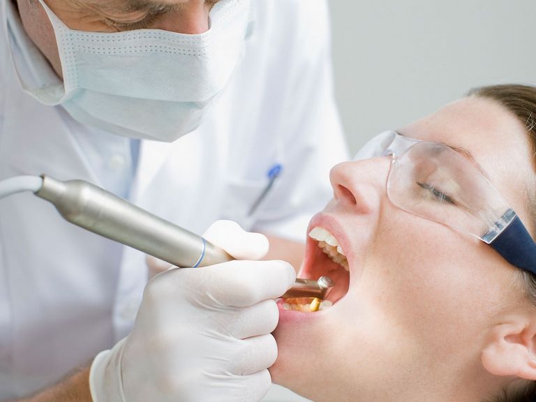 Frau lässt eine professionelle Zahnreinigung vornehmen