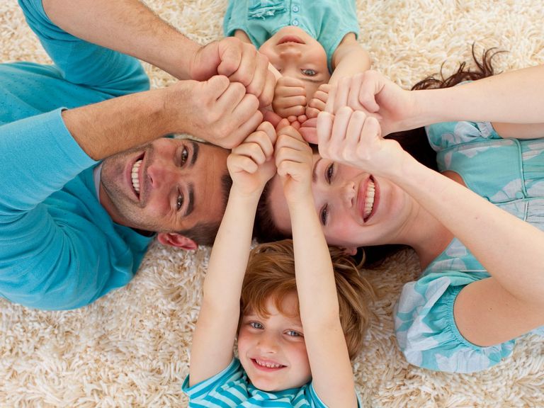 Familien liegt auf den Boden und drückt alle Daumen