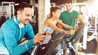 Musik im Training Mann im Sportdress sucht sich für sein Training die richtige Musik auf seinem Smartphone aus