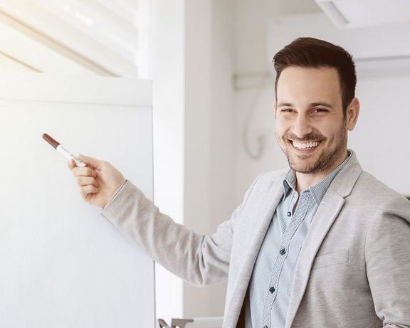 IKK-Jahreswechselseminare Ein Büro-Mitarbeiter präsentiert etwas vor einem Flipchart
