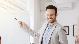 Ein Büro-Mitarbeiter präsentiert etwas vor einem Flipchart