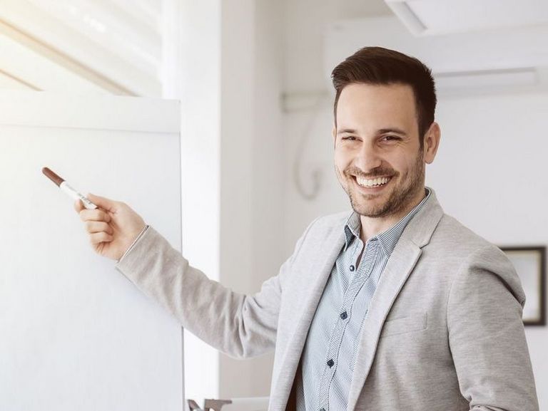 Ein Büro-Mitarbeiter präsentiert etwas vor einem Flipchart