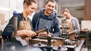 Macher im Handwerk kleines Team an Mitarbeitern arbeitet mit Freude in einer Werkstatt