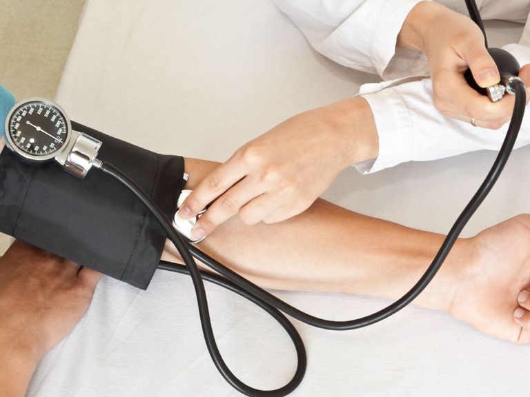 Arzt misst Blutdruck bei Patientin