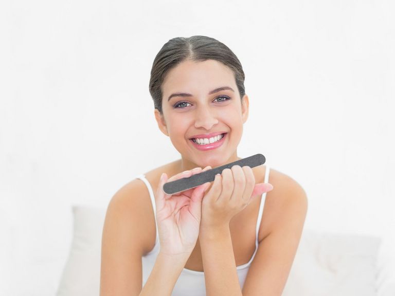 Frau feilt ihre Nägel