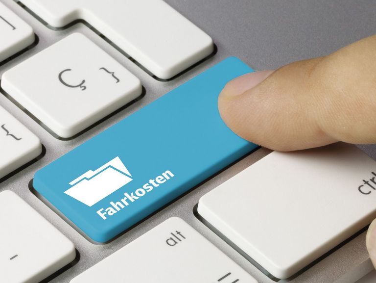 Zeigefinger tippt auf eine Taste mit der Aufschrift Fahrkosten