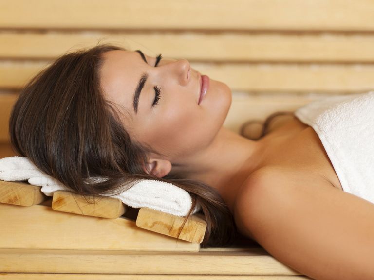 Frau liegt in der Sauna und entspannt