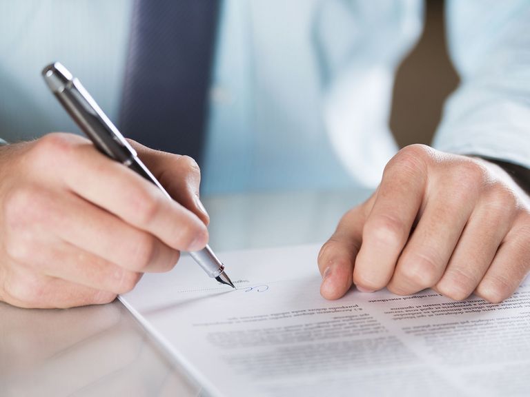 Mann unterschreibt ein Schriftstück