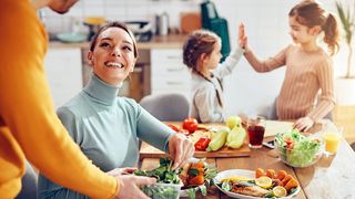 Familie mit zwei Töchtern bei der gemeinsamen Essenszubereitung