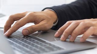 Meldeportal für Arbeitgeber Männerhände tippen auf einer Laptoptastatur