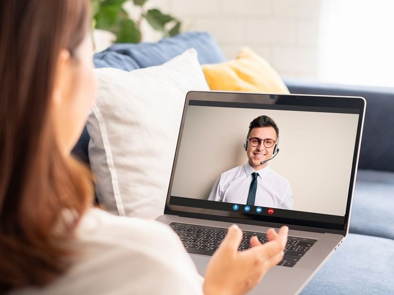 Frau auf Sofa sitzend hat einen Service-Videocall