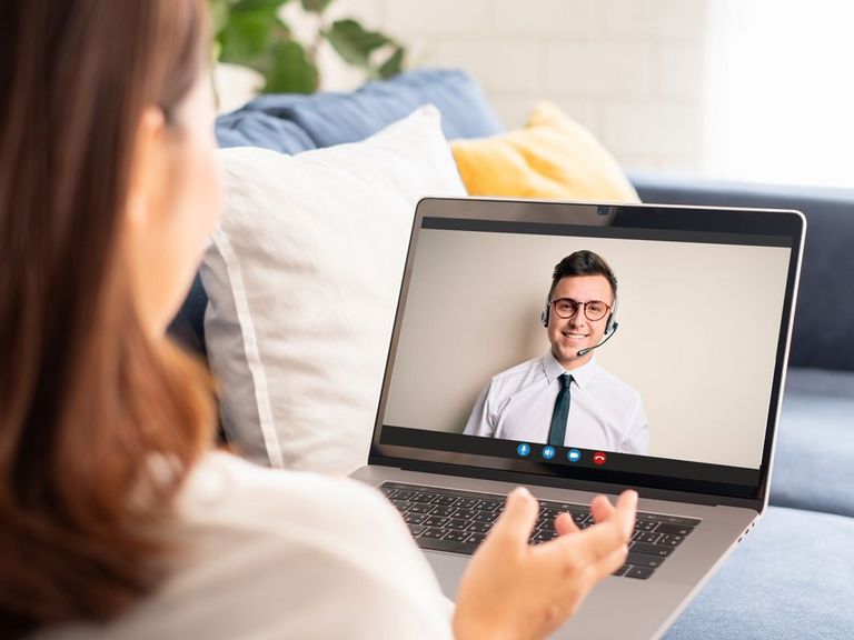 Frau auf Sofa sitzend hat einen Service-Videocall