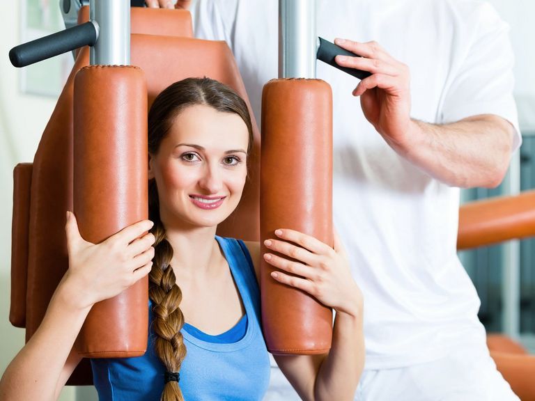 Junge Frau trainiert in stationärer Reha