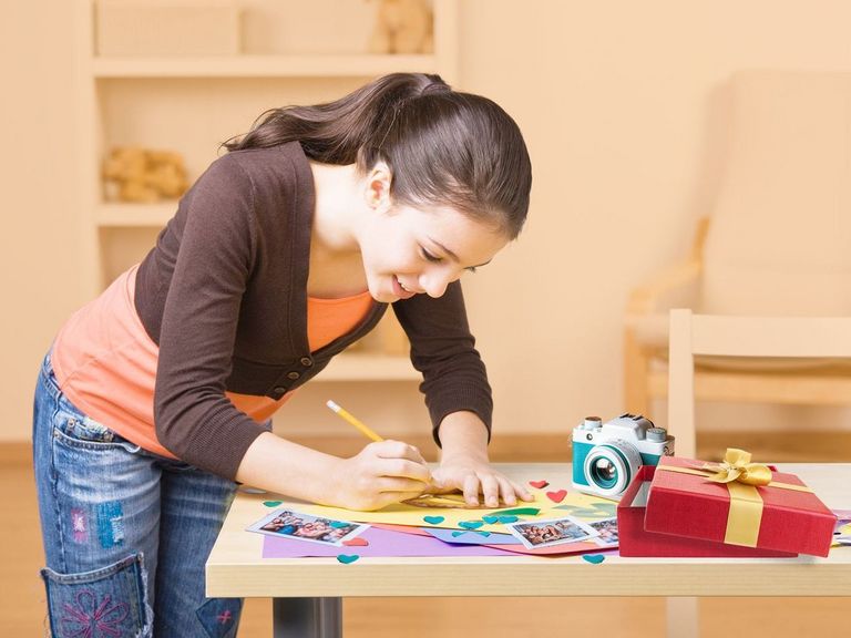 Teenagerin bastelt mit Hingabe Geschenke für Weihnachten