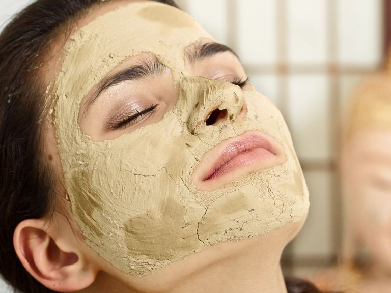 Junge Frau mit einer Gesichtsmaske aus Heilerde